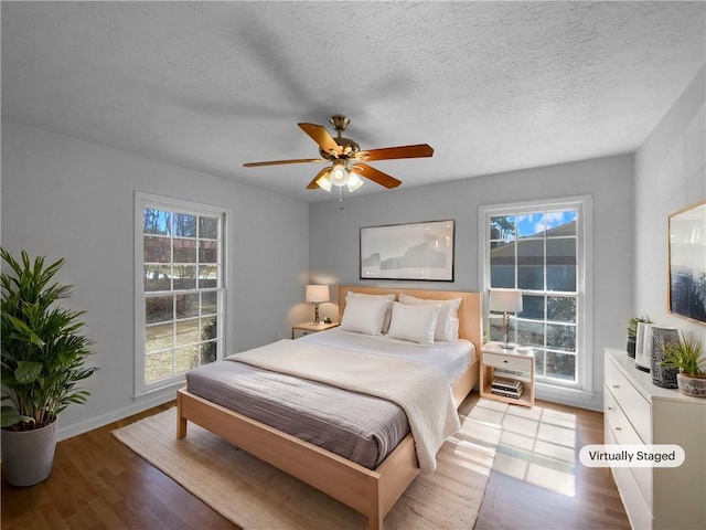 8005 Bamby Ln, Jonesboro, GA 30236 - bedroom featuring a textured ceiling, baseboards, a ceiling fan, and light wood-style floors