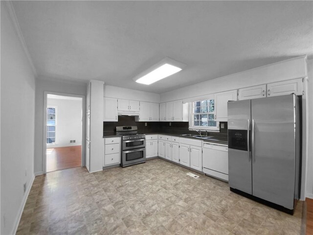 8005 Bamby Ln, Jonesboro, GA 30236 - kitchen featuring dark countertops, white cabinets, stainless steel appliances, and a sink