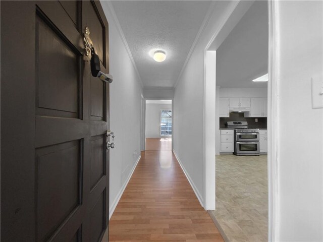 8005 Bamby Ln, Jonesboro, GA 30236 - hall featuring light wood-style floors, baseboards, ornamental molding, and a textured ceiling