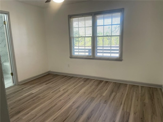 empty room with ceiling fan and hardwood / wood-style floors