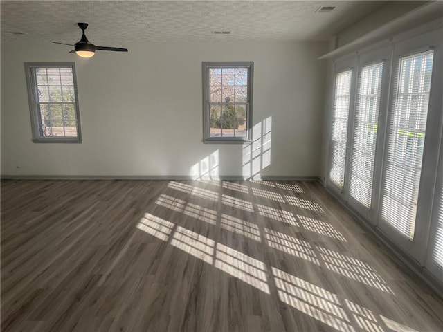 unfurnished room featuring ceiling fan, dark wood-type flooring, and a textured ceiling