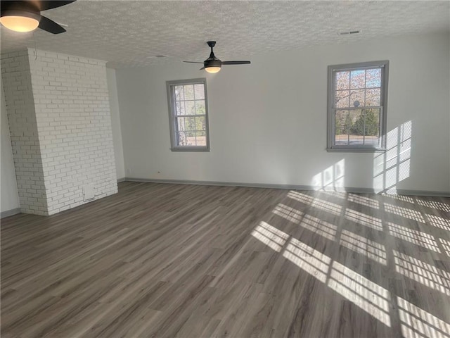 unfurnished living room featuring ceiling fan, dark wood-type flooring, and a textured ceiling