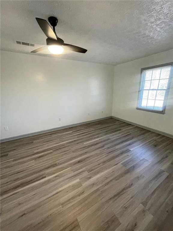 unfurnished room with ceiling fan, a textured ceiling, and hardwood / wood-style floors