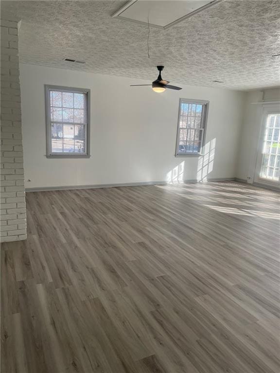 unfurnished living room featuring a textured ceiling, ceiling fan, and hardwood / wood-style flooring