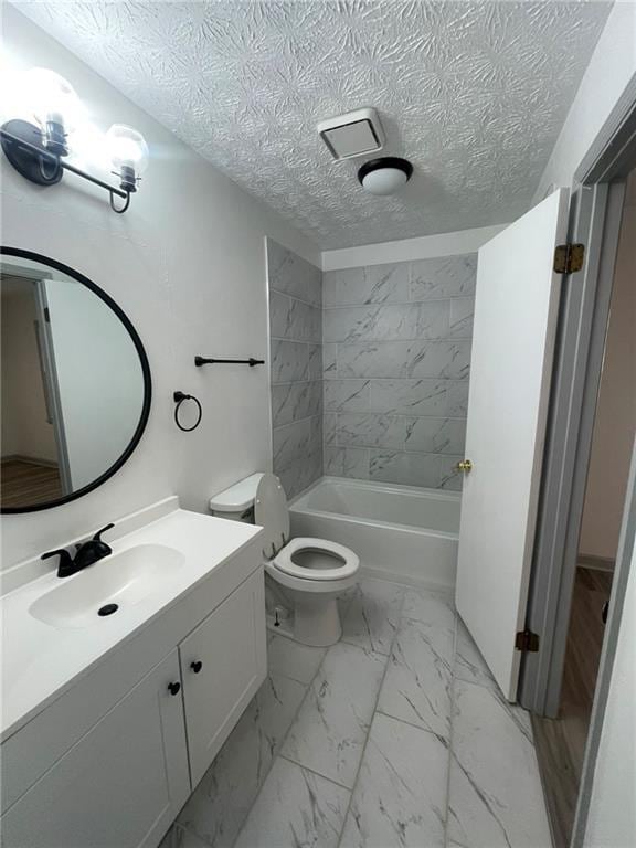 full bathroom featuring toilet, vanity, tiled shower / bath combo, and a textured ceiling