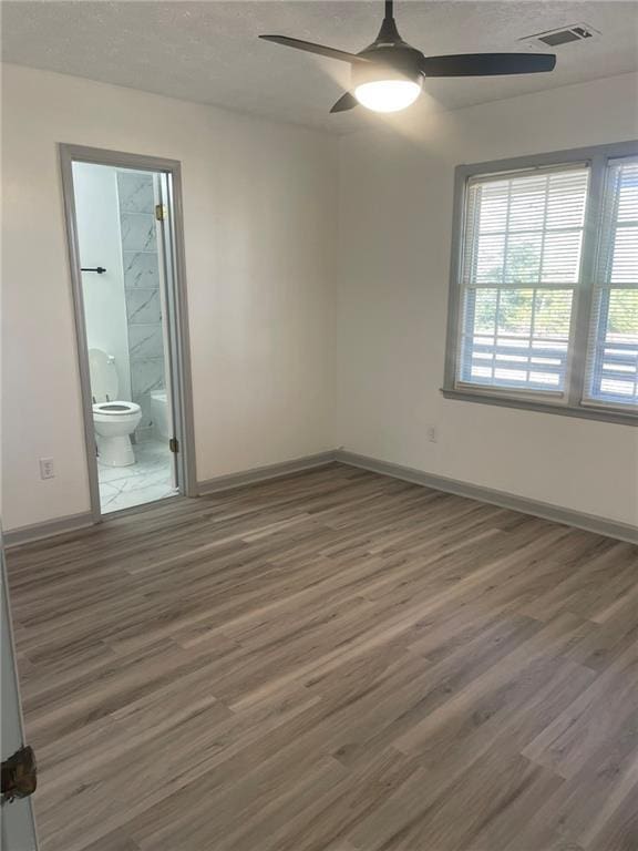 spare room with ceiling fan and dark hardwood / wood-style floors