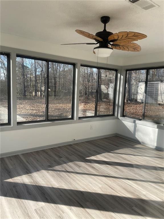 unfurnished sunroom with ceiling fan