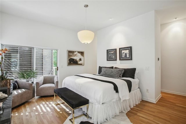 bedroom with wood-type flooring and access to outside