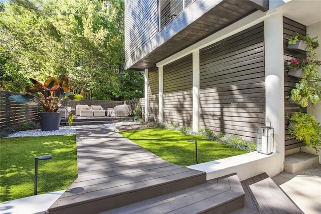 wooden terrace featuring an outdoor hangout area and a yard