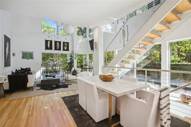 dining space with wood-type flooring and a high ceiling