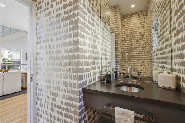 interior space featuring hardwood / wood-style flooring, brick wall, and sink