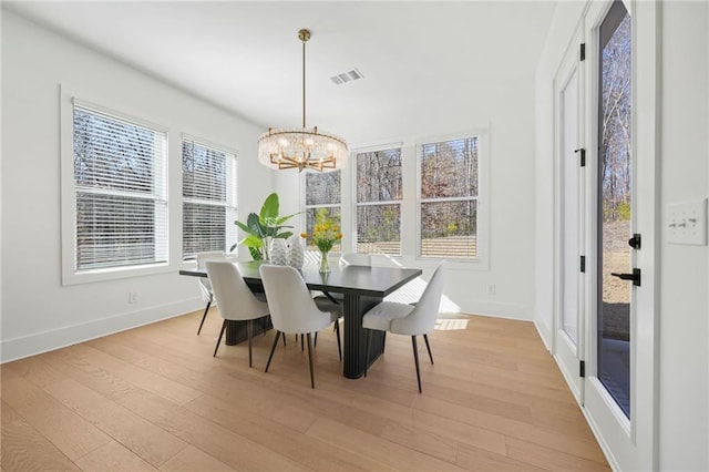 dining room with light wood-style floors, a notable chandelier, visible vents, and a wealth of natural light