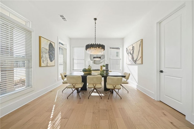 dining space with a chandelier, visible vents, light wood-style floors, and baseboards