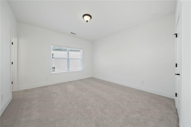 unfurnished room featuring light carpet, visible vents, and baseboards