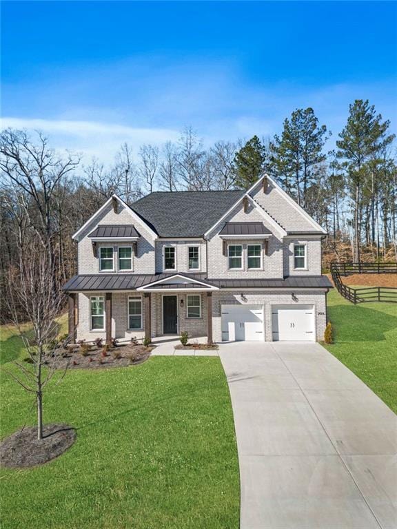 view of front of house with driveway, metal roof, an attached garage, a standing seam roof, and a front lawn