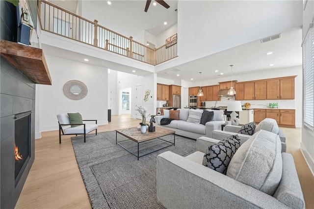 living room with a towering ceiling and light wood-type flooring