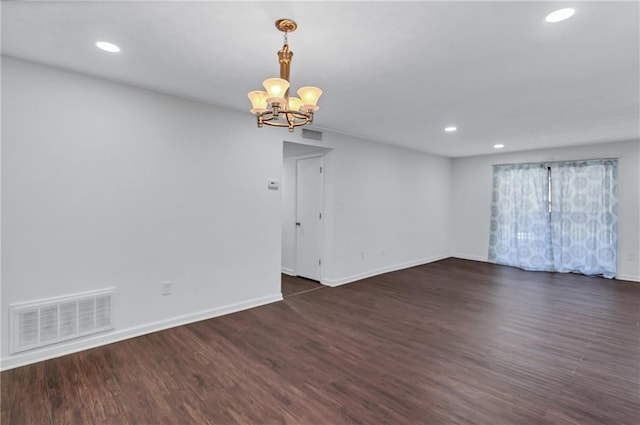 unfurnished room featuring dark hardwood / wood-style flooring and a chandelier