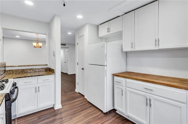 kitchen featuring white cabinets, butcher block counters, range with gas stovetop, and white fridge