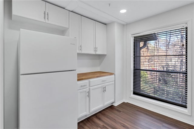 kitchen with white refrigerator, white cabinetry, dark hardwood / wood-style floors, and wooden counters