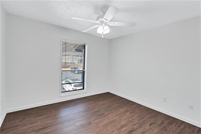 spare room featuring ceiling fan, a wealth of natural light, and dark wood-type flooring