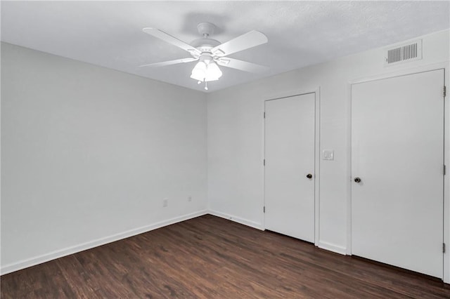 unfurnished bedroom featuring ceiling fan and dark wood-type flooring