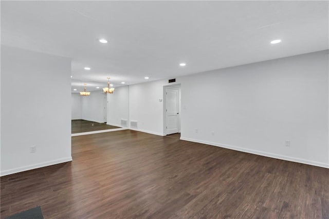 unfurnished living room with dark hardwood / wood-style flooring and an inviting chandelier