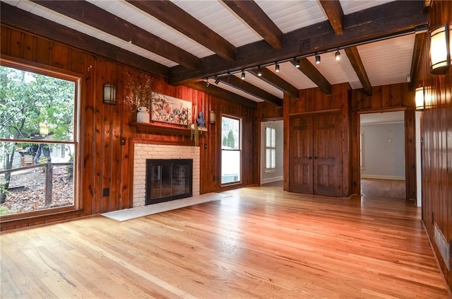 970 Winding Creek Trl, Sandy Springs, GA 30328 - unfurnished living room featuring rail lighting, wooden walls, beam ceiling, a fireplace, and wood finished floors