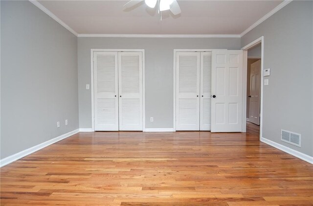 970 Winding Creek Trl, Sandy Springs, GA 30328 - unfurnished bedroom featuring two closets, ornamental molding, light wood-style floors, and a ceiling fan