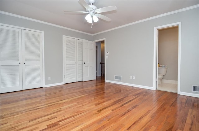 970 Winding Creek Trl, Sandy Springs, GA 30328 - unfurnished bedroom featuring two closets, light wood-type flooring, crown molding, ensuite bath, and a ceiling fan