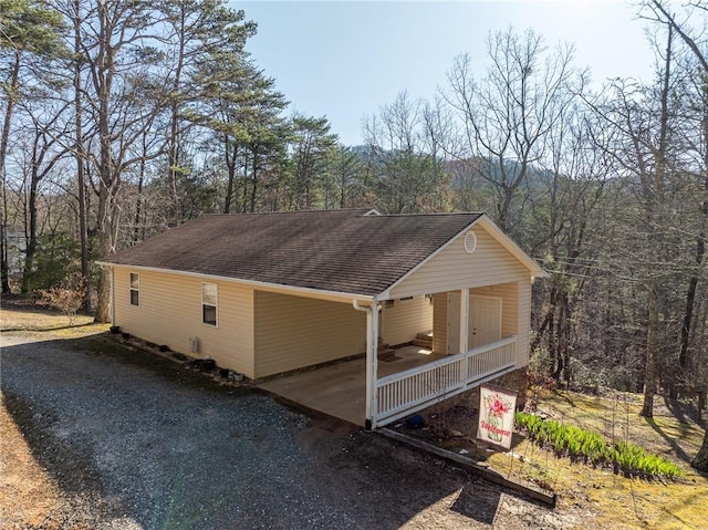 1700 Greenfield Rd, Ellijay, GA 30536 - view of home's exterior with a porch, a shingled roof, a wooded view, and driveway