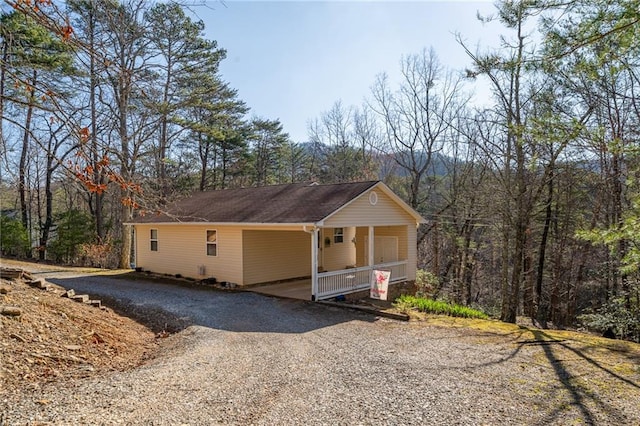 1700 Greenfield Rd, Ellijay, GA 30536 - view of side of property featuring gravel driveway, a carport, a wooded view, and covered porch