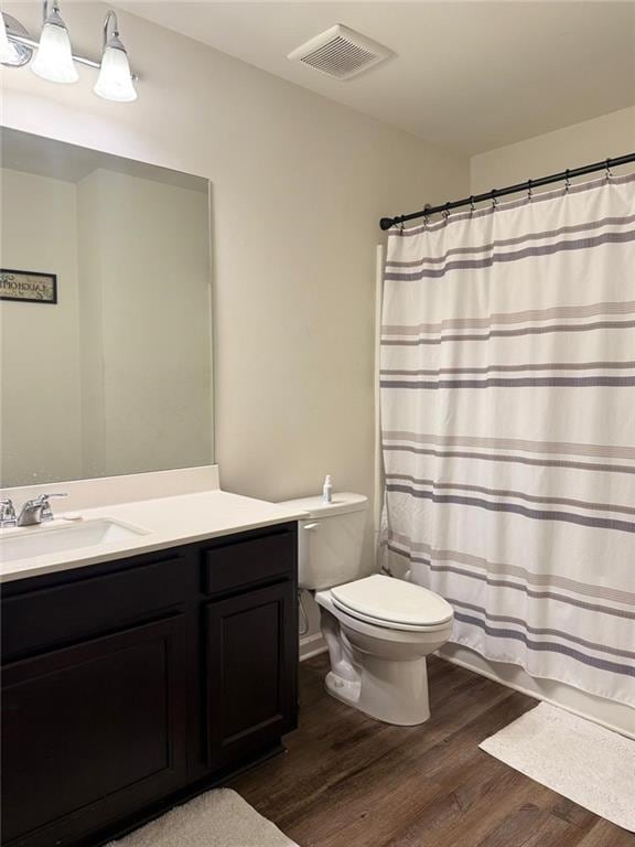 bathroom featuring vanity, hardwood / wood-style flooring, and toilet