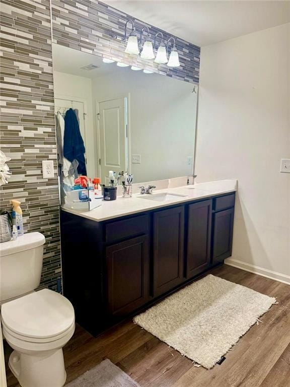 bathroom with vanity, toilet, hardwood / wood-style floors, and tile walls