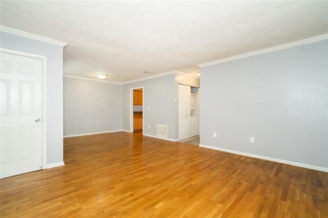 spare room with ornamental molding and light hardwood / wood-style floors