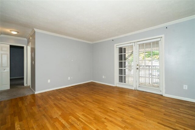 unfurnished room featuring french doors, light hardwood / wood-style floors, and ornamental molding