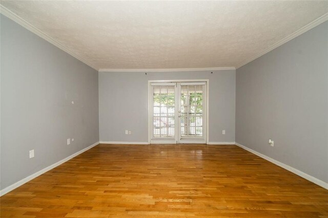 spare room featuring light hardwood / wood-style flooring, french doors, and crown molding