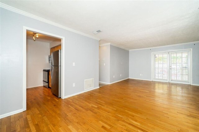 unfurnished room featuring ornamental molding and light hardwood / wood-style flooring