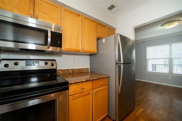 kitchen featuring dark stone counters, dark hardwood / wood-style flooring, and stainless steel appliances