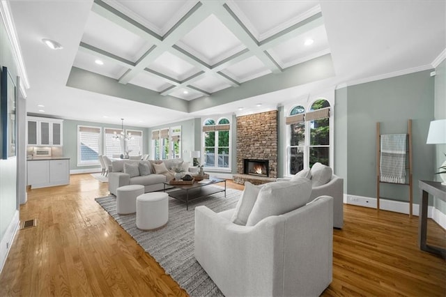 745 Glengate Pl, Atlanta, GA 30328 - living room with light wood-style floors, coffered ceiling, beamed ceiling, a stone fireplace, and a chandelier