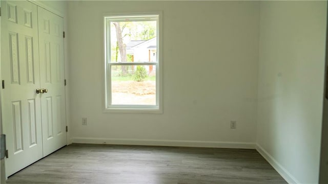 unfurnished bedroom featuring multiple windows and light hardwood / wood-style flooring