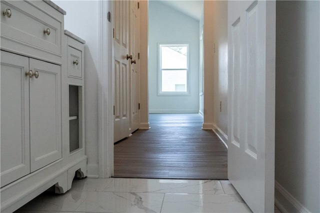 hallway featuring vaulted ceiling and light wood-type flooring