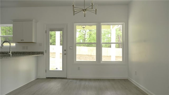 doorway with sink, a chandelier, and light hardwood / wood-style floors