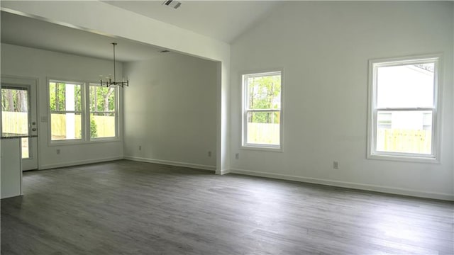 spare room featuring a healthy amount of sunlight and dark hardwood / wood-style flooring