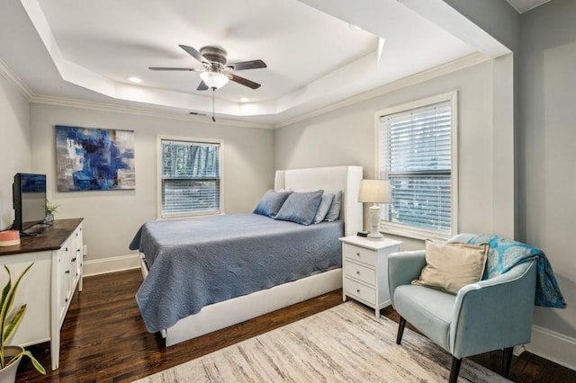 bedroom with a tray ceiling, dark wood-type flooring, and ornamental molding