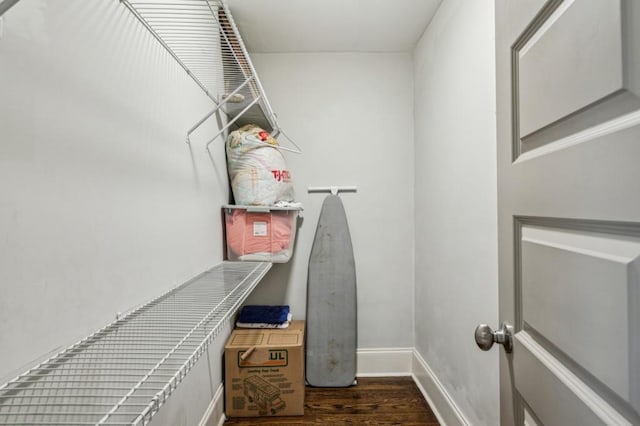 walk in closet with dark wood-type flooring