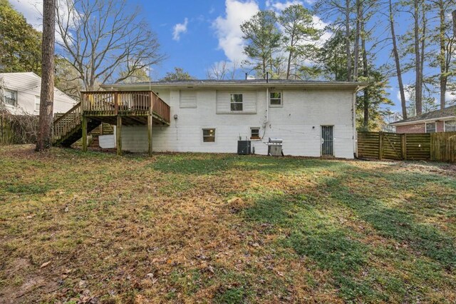 rear view of property featuring a wooden deck, central AC, and a lawn