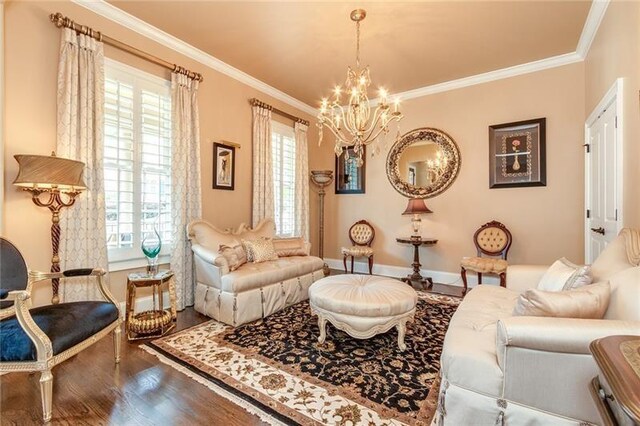 living area featuring ornamental molding, a notable chandelier, baseboards, and wood finished floors