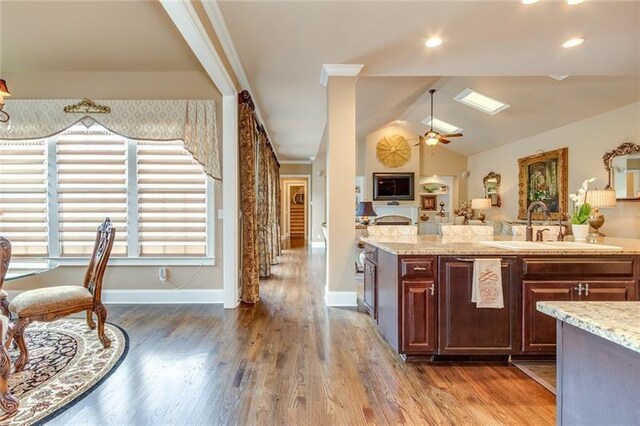 kitchen featuring ceiling fan, dark wood-type flooring, a sink, and lofted ceiling