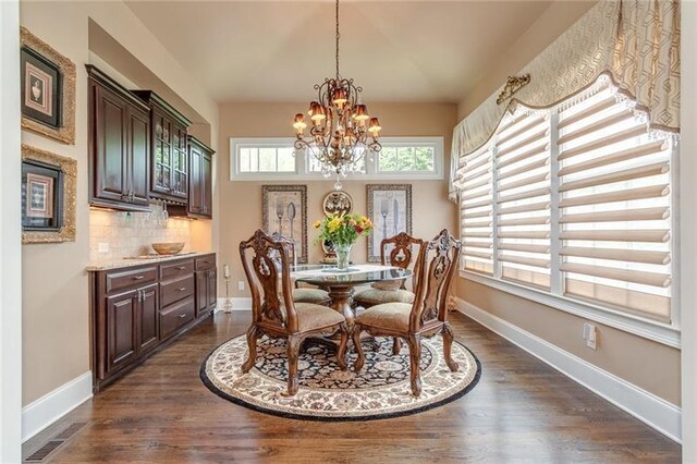 dining space featuring a notable chandelier, visible vents, baseboards, and dark wood-style flooring