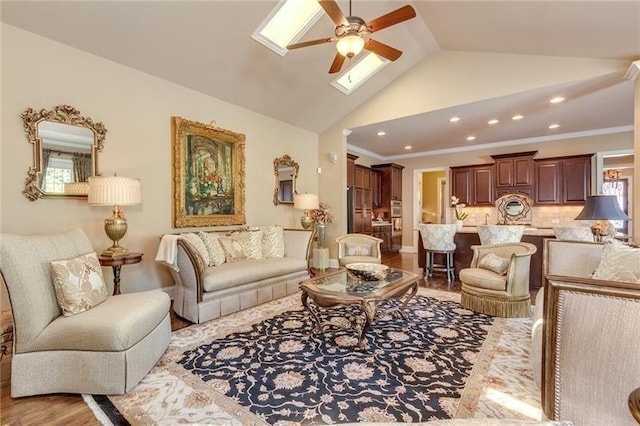 living room featuring recessed lighting, lofted ceiling with skylight, light wood-type flooring, and crown molding